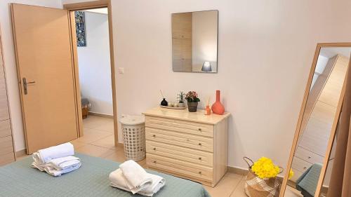 a bathroom with a dresser and a mirror at Lakithra Apartments in Kefallonia