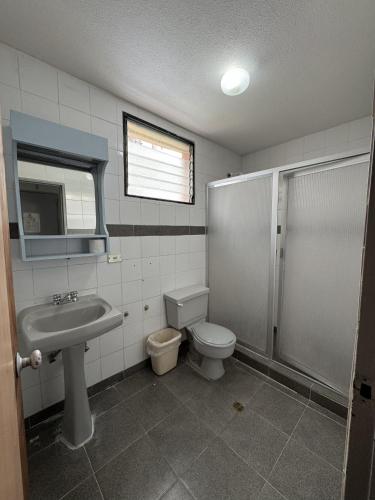 a bathroom with a toilet and a sink and a shower at Hotel Harmony in Caracas