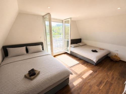 a bedroom with two beds and a large window at Vikendica Bregovi in Doboj