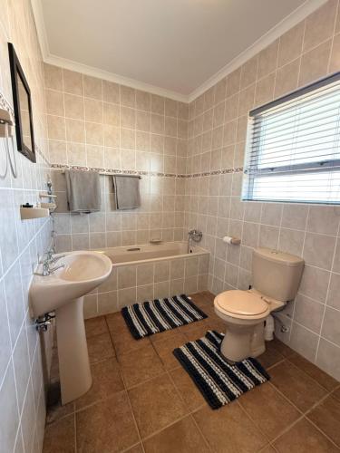 a bathroom with a toilet and a sink and a tub at Praia Longa 4 in Rand Rifles