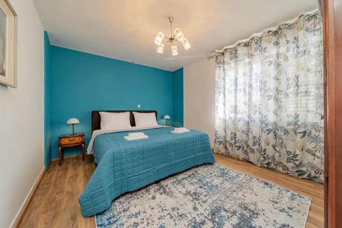 a blue bedroom with a bed and a blue wall at Trogir apartments in Trogir
