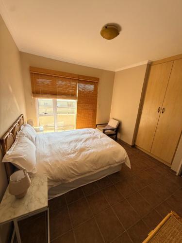 a bedroom with a white bed and a window at Praia Longa 4 in Rand Rifles
