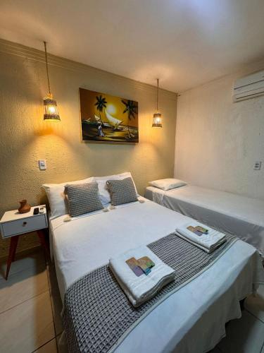 a hotel room with two beds with towels on them at Pousada Marúa Fortaleza in Fortaleza