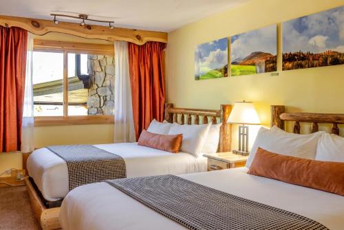 a hotel room with two beds and a window at Adirondack Spruce Lodge in Wilmington