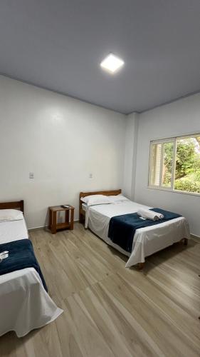 a room with two beds and a window at Lago Azul Acqua Park in Santo Cristo