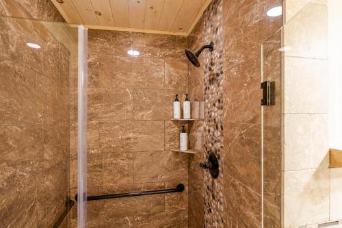 a bathroom with a shower with a glass door at Adirondack Spruce Lodge in Wilmington