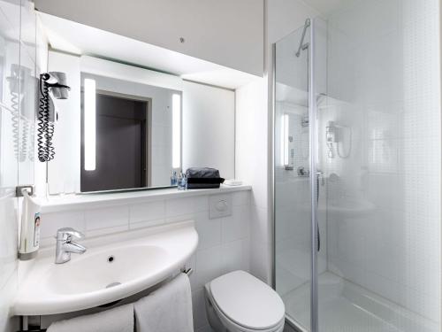 a bathroom with a sink and a toilet and a shower at ibis Mainz City in Mainz