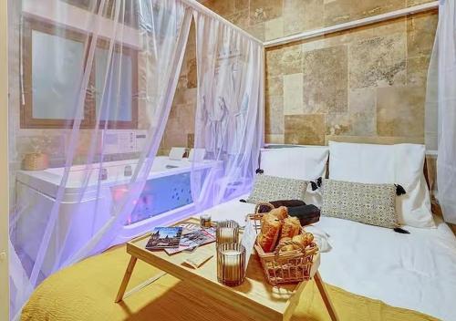 a bed with a table with a tray of food on it at Bed & Spa - La Parenthese in Dijon