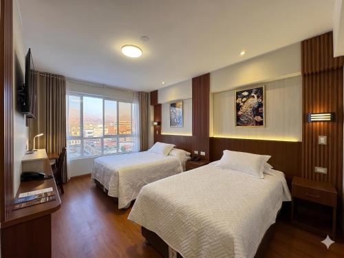 a hotel room with two beds and a window at Hotel Yanahuara Suite in Arequipa