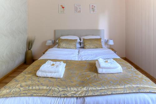 a bedroom with a bed with towels on it at Kaposvár Deluxe Apartman in Kaposvár