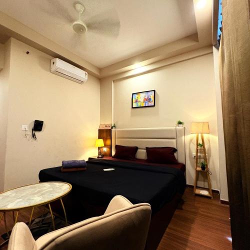 a bedroom with a bed and a table and chairs at Glow Corner in Greater Noida