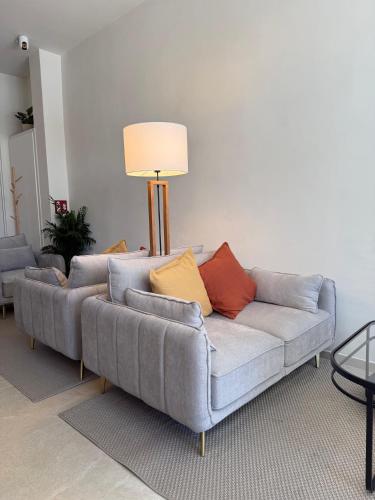 a living room with a gray couch with colorful pillows at Hotel LUMIè Pescasseroli in Pescasseroli