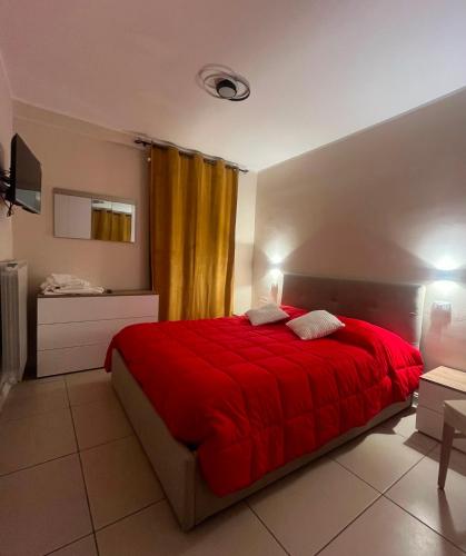 a bedroom with a bed with a red blanket at Caraceni Apartaments 2 in Castel di Sangro