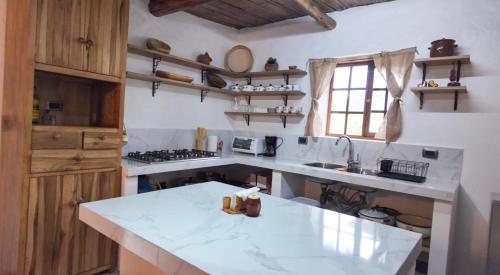 a kitchen with a white counter top and a sink at Lodge La Ilusión in Ibarra