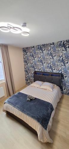 a bed in a room with a blue and white wall at Le Square Inn in Turckheim