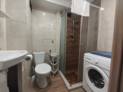 a bathroom with a toilet and a washing machine at Mieszkanie Solina in Solina