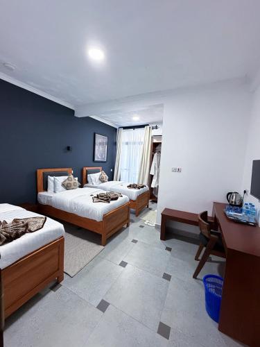 a hotel room with two beds and a desk and a desk at Njiro Luxury in Arusha