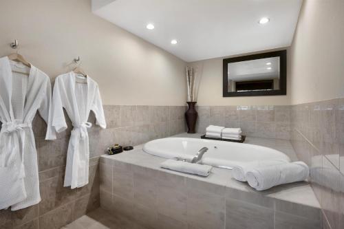 a bathroom with a bath tub and a tv at Best Western Plus Coeur d'Alene Inn in Coeur d'Alene