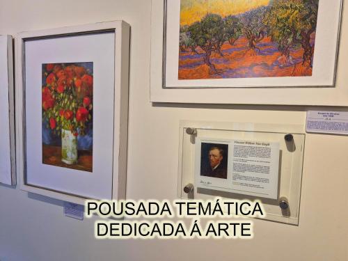 a exhibit at a museum with paintings on a wall at Belle Arti Pousada in Florianópolis