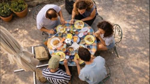 a group of people sitting around a table eating food at villa marguerite in Lunas