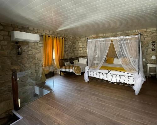 a bedroom with a bed with a mosquito net at Casa do Torreão in Trancoso