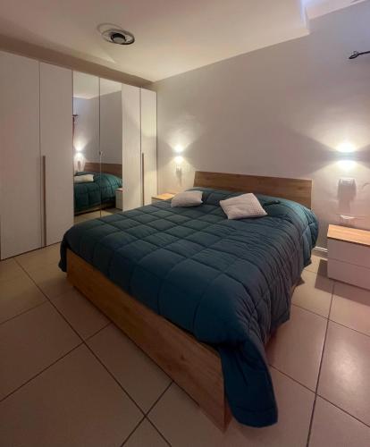 a bedroom with a large bed with a blue blanket at Caraceni Apartaments 1 in Castel di Sangro