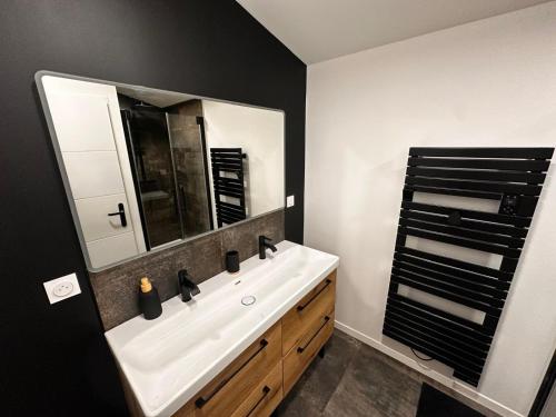 a bathroom with a white sink and a mirror at BlakRiverHouse - Sèvre Niortaise in Niort