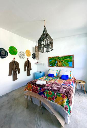 a bedroom with a bed and paintings on the wall at Studio Havaí - Village Capixaba in Gravatá