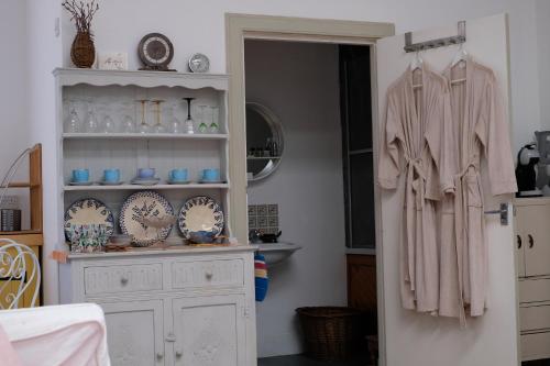 a room with a white cabinet and a shelf with dishes at ‘Museum Loft’ Scotland’s Wee Hat Museum in Newburgh