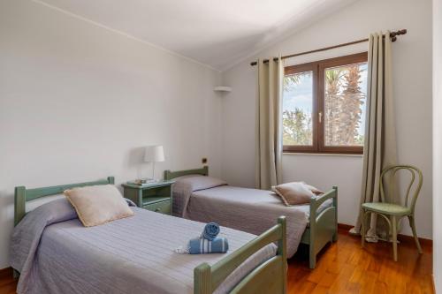 a bedroom with two beds and a window at Villa Cielo in Paceco