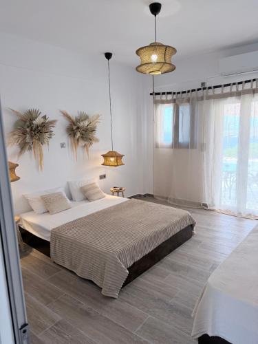 a bedroom with two beds and two pendant lights at Kanal Vstay #1 in Kithnos