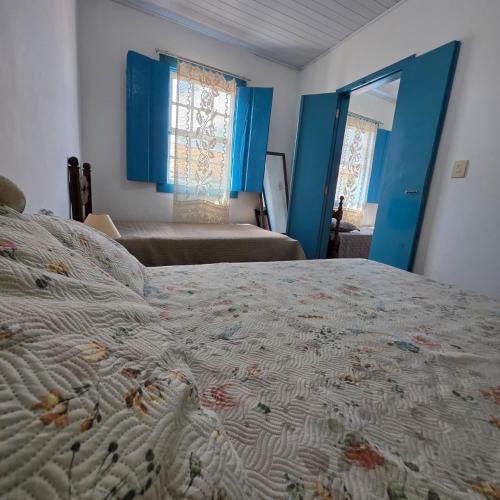 a bedroom with a bed and a window and a mirror at Casa Centro Exclusiva Diamantina in Diamantina