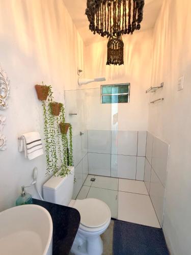 a bathroom with a toilet and a glass shower at Studio Havaí - Village Capixaba in Gravatá