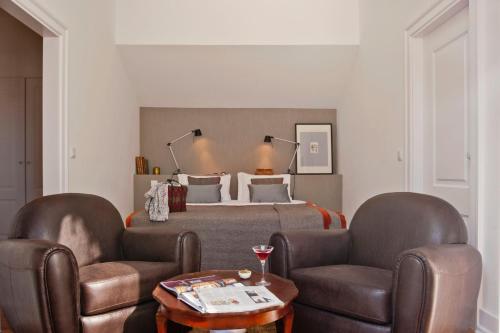 a bedroom with a bed and two chairs and a table at Casa Balthazar in Lisbon