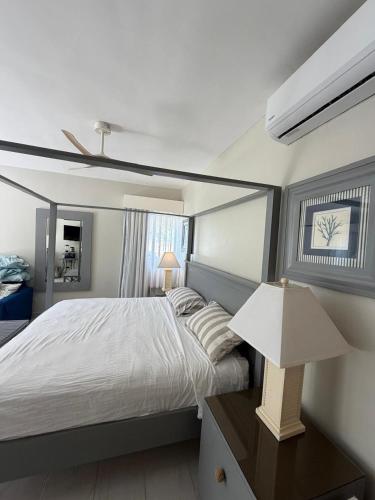 a bedroom with a bed and a lamp on a table at Cadaques Caribe Bayahibe Palmera in Bayahibe