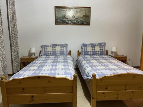 two twin beds in a bedroom with a painting on the wall at pensione VAIS in Piotta