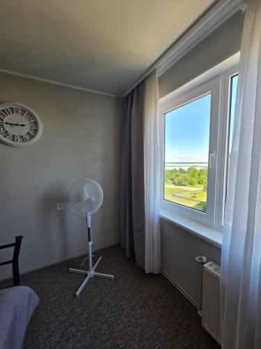 a room with a large window and a fan at Lake Breeze Stay in Liepāja