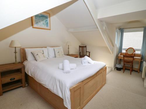 a bedroom with a large bed with white sheets at Kipper Lodge in Dartmouth