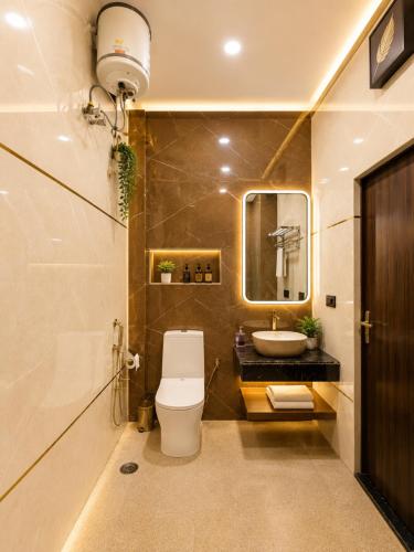 a bathroom with a toilet and a sink and a mirror at Stay By Shree Dharan Inn Near Shree Ram Mandir Ayodhya in Ayodhya