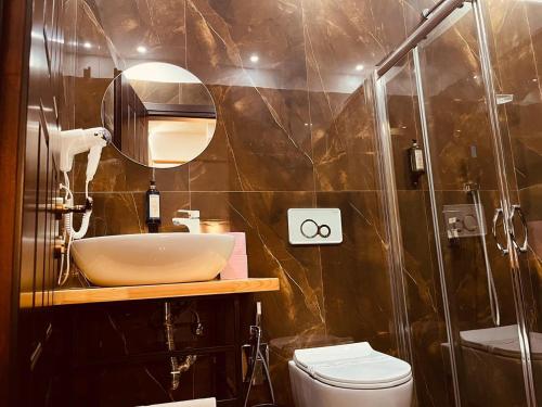 a bathroom with a sink and a shower and a toilet at Comfort Hotel in Fier