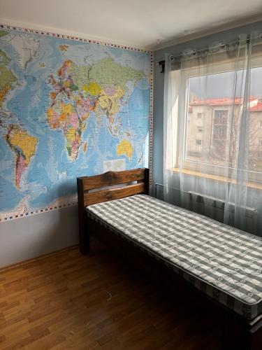 a bed in a room with a map of the world at Mugavustega avar perekorter 3toaline in Võru
