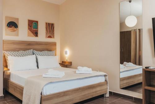 a bedroom with a large bed and a mirror at Level 3 Sea View Studio in Planos
