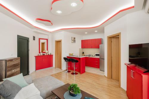 a living room with red cabinets and a kitchen at Apartman Stella Đenovići in Đenovići