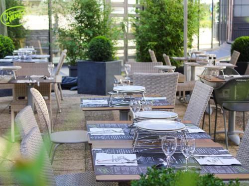 a table with plates and wine glasses on a patio at ibis Styles Evry Courcouronnes Hotel and Events in Courcouronnes