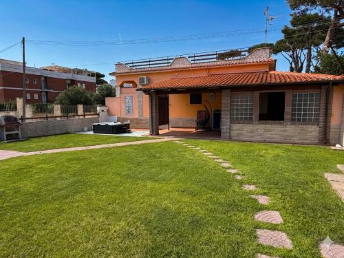 a house with a green lawn in front of it at 'Villa Vènere Deluxe' 50mt Sea-Jacuzzi-Free Parking-Garden in Terracina