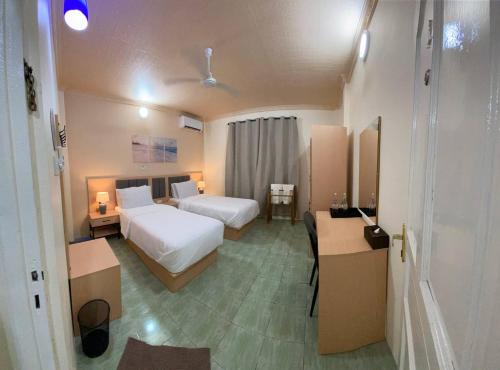 a hotel room with two beds and a desk at EcoWave Retreat- Muli in Muli