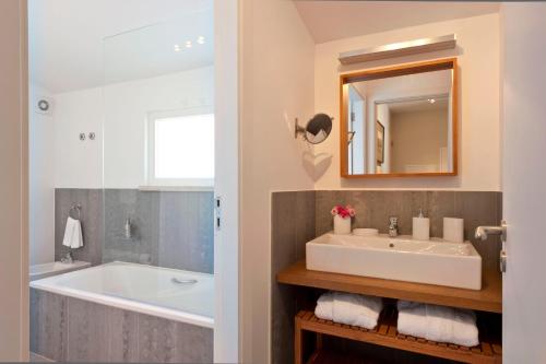 a bathroom with a sink and a tub and a mirror at Casa Balthazar in Lisbon