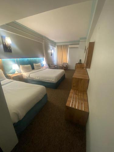 a hotel room with two beds and a bench at فندق قصر السدير in Baghdād