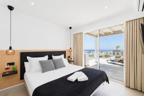 a bedroom with a large bed and a balcony at Villa Maria 7 in Puerto Calero