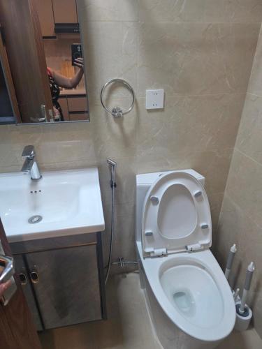 a bathroom with a toilet and a sink and a mirror at Megarich Studio in Megatower VII in Baguio